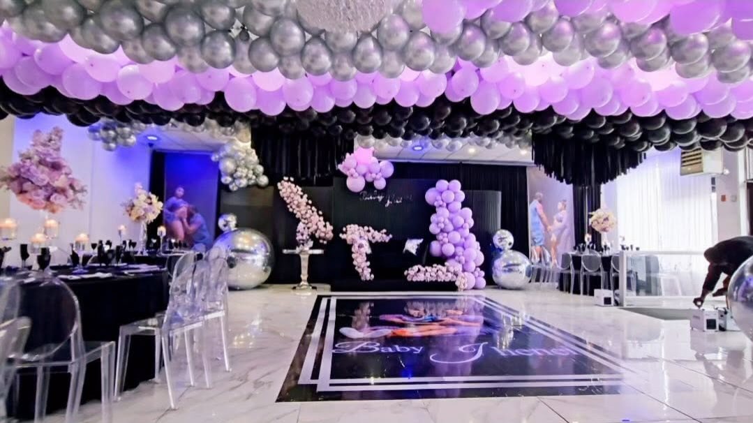 The event hall with a black, silver and lilac balloon ceiling and a custom dance floor at La Mansion Venue
